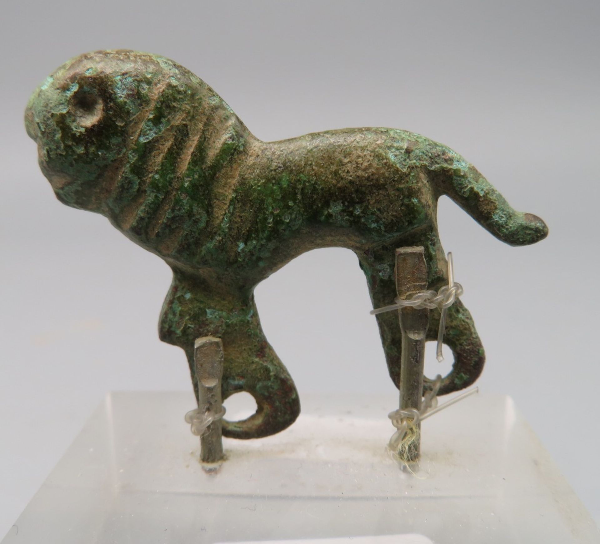Antiker Rüstungsbeschläg in Gestalt eines stehenden Löwens, wohl Römisch, Bronze, 3 x 3,7 x 0,5 cm,