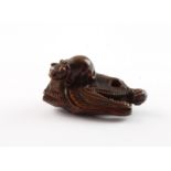 NETSUKE KATZE AUF EINEM FISCHKOPF, Buchsbaum, die katze mit fleckigem Fell und Schleife sitzt auf e