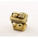 NETSUKE TISCH, Elfenbein, auf dem Tisch liegen ein Buch und ein Hut, H 3,2, sign. Hideshige, JAPAN,