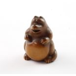 NETSUKE TANUKI NO HARATSUZUMI, Holz, Augen schwarzes Horn, sitzend und auf seinen Bauch trommelnd,