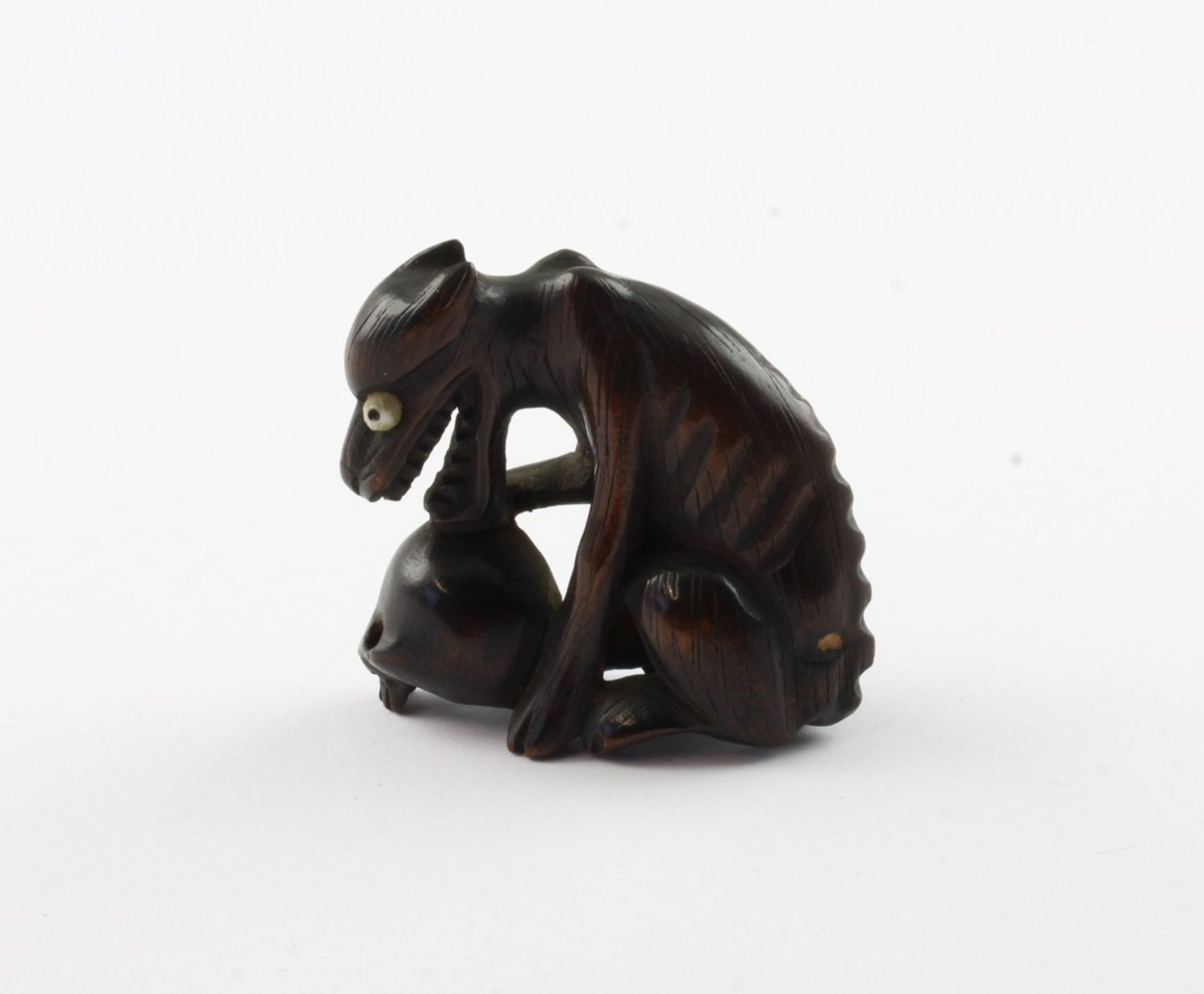 NETSUKE WOLF UND TOTENKOPF, dunkel gefärbtes Holz, Augen Bein, ein magerer Wolf kauert über einem S - Bild 2 aus 3