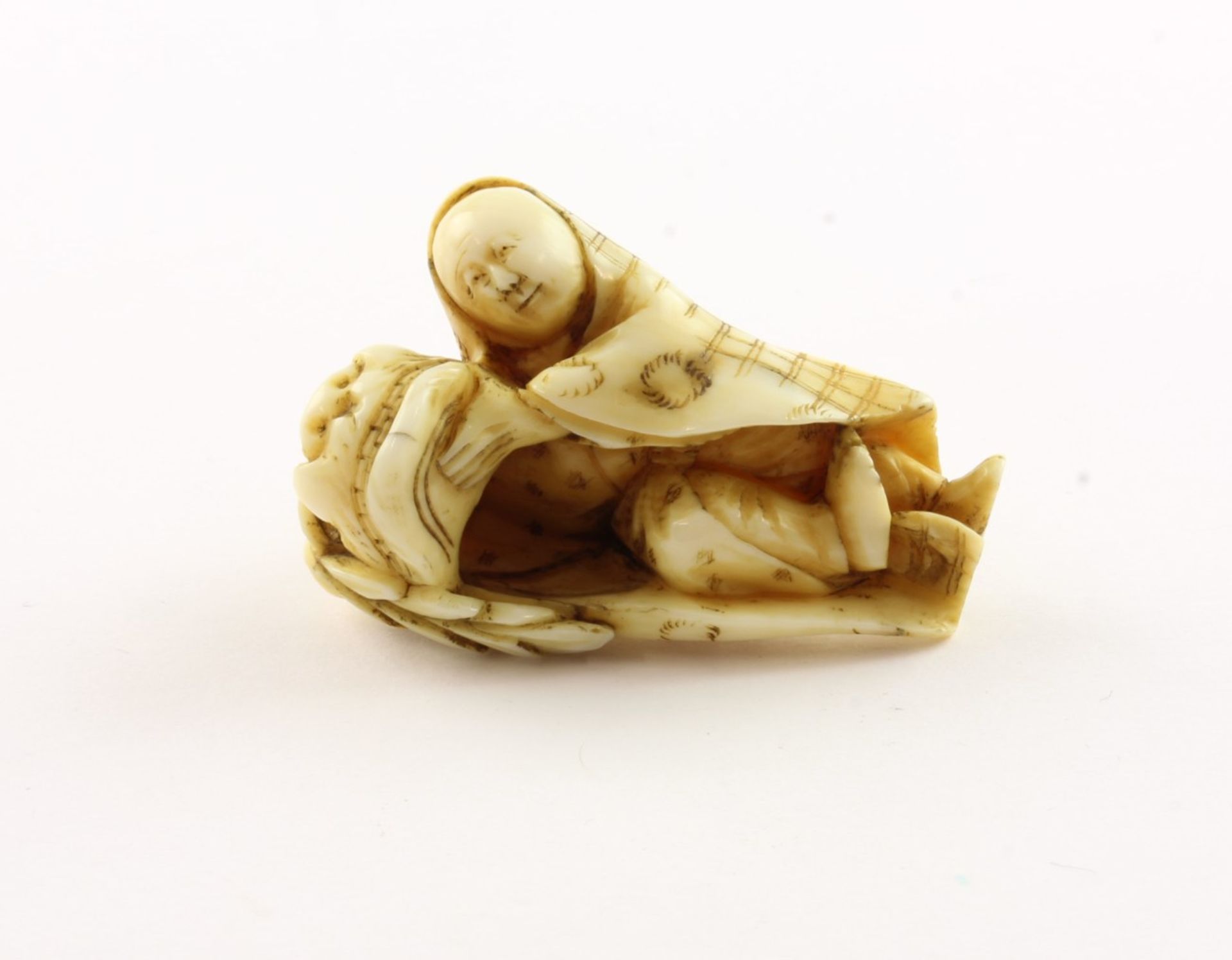 NETSUKE SHISHIMAI-TÄNZER, Elfenbein, der Tänzer hält mit beiden Händen eine große Shishi-Maske, H 4