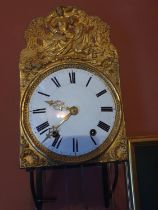 Unmarked 19thC wall hanging clock in open form with circular enamel face and extensive pattered gilt
