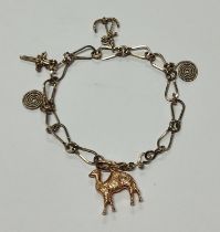 Gold coloured charm bracelet with various charms, the camel clasp is marked 16K 8.8 grams gross