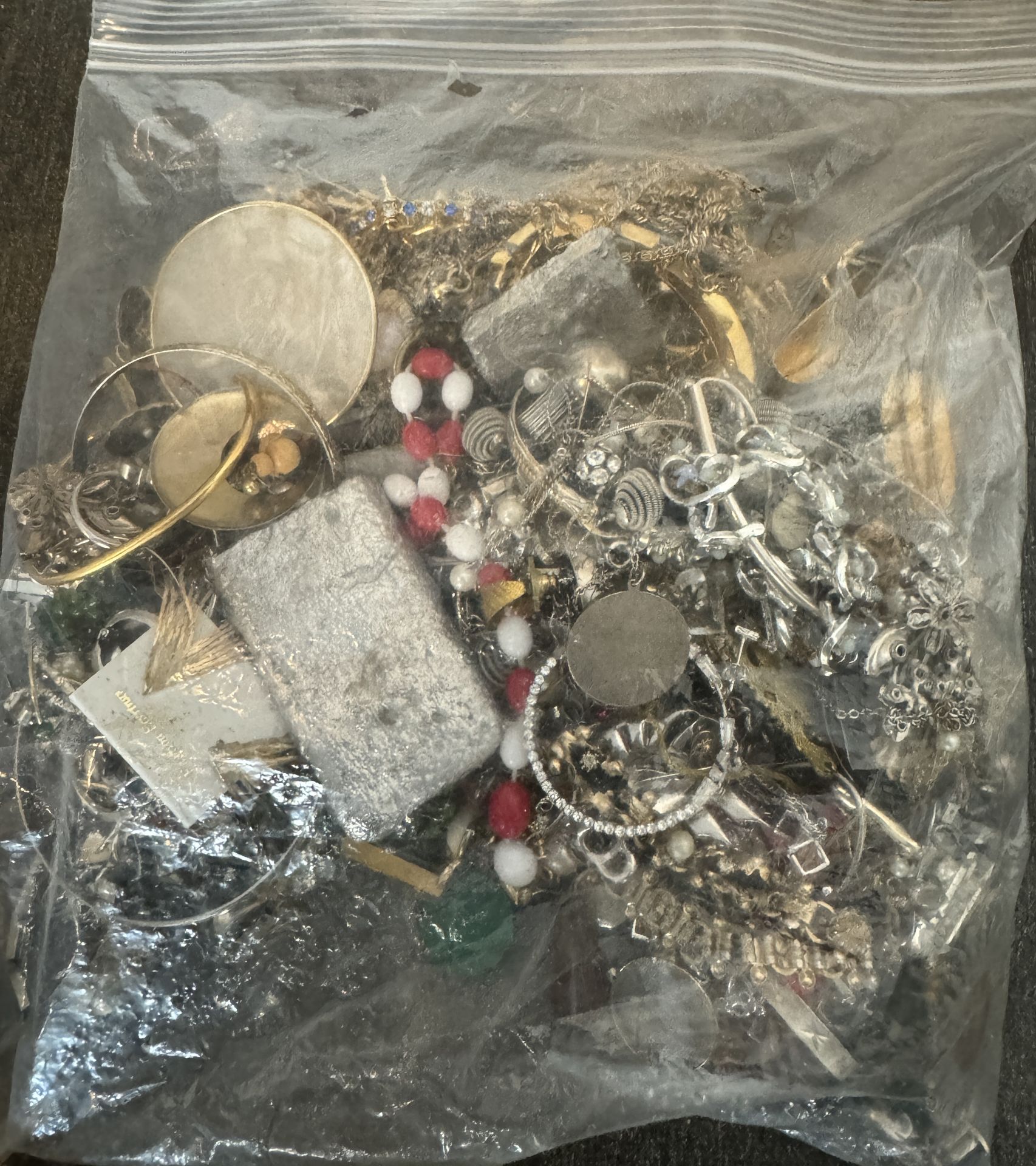 BAG OF MIXED UNSORTED JEWELRY / SOME SORT OF SILER BRICK INSIDE IT