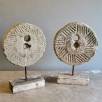 Matched pair of sandstone mill stones mounted on a iron rod and driftwood bases, 32 cm wide, 11 cm