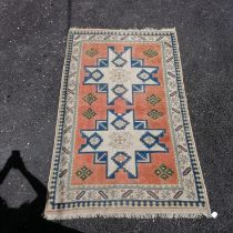 Cream and pink ground eastern wool rug. 133cm x 217cm. In good used condition