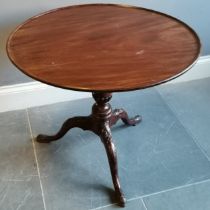 Antique mahogany tilt top occasional table on turned and reeded column terminating on carved