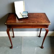 Antique figured walnut foldover card table on cabriole legs with inset brown cloth detail & with