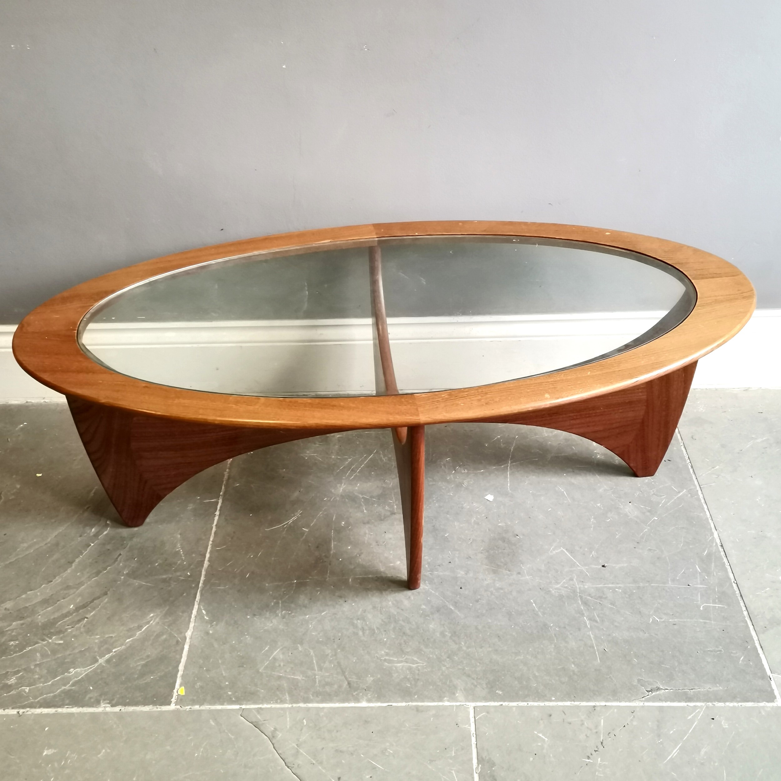 Mid century G Plan astro oval coffee table with inset glass top on stylized base by Victor Wilkins