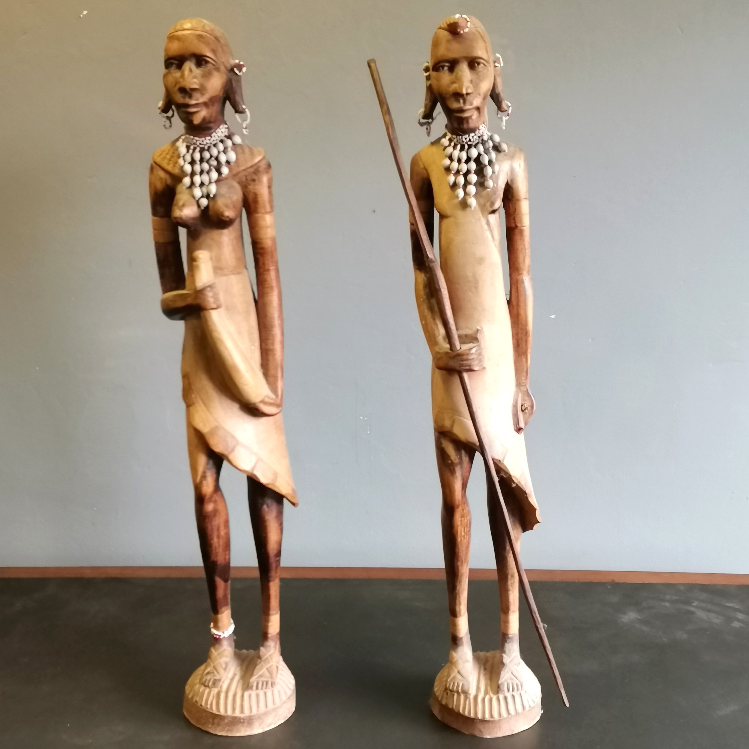 Pair of African Tribal hardwood figures male and female each with beaded and shell collars, The male
