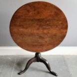 Antique oak tilt top circular table on turned column terminating on tripod base, 73cm diameter x