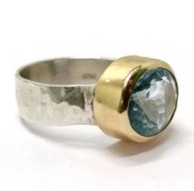 Silver blue topaz ring with unmarked gold mount and planished detail to shank - size Q½ & 6.9g