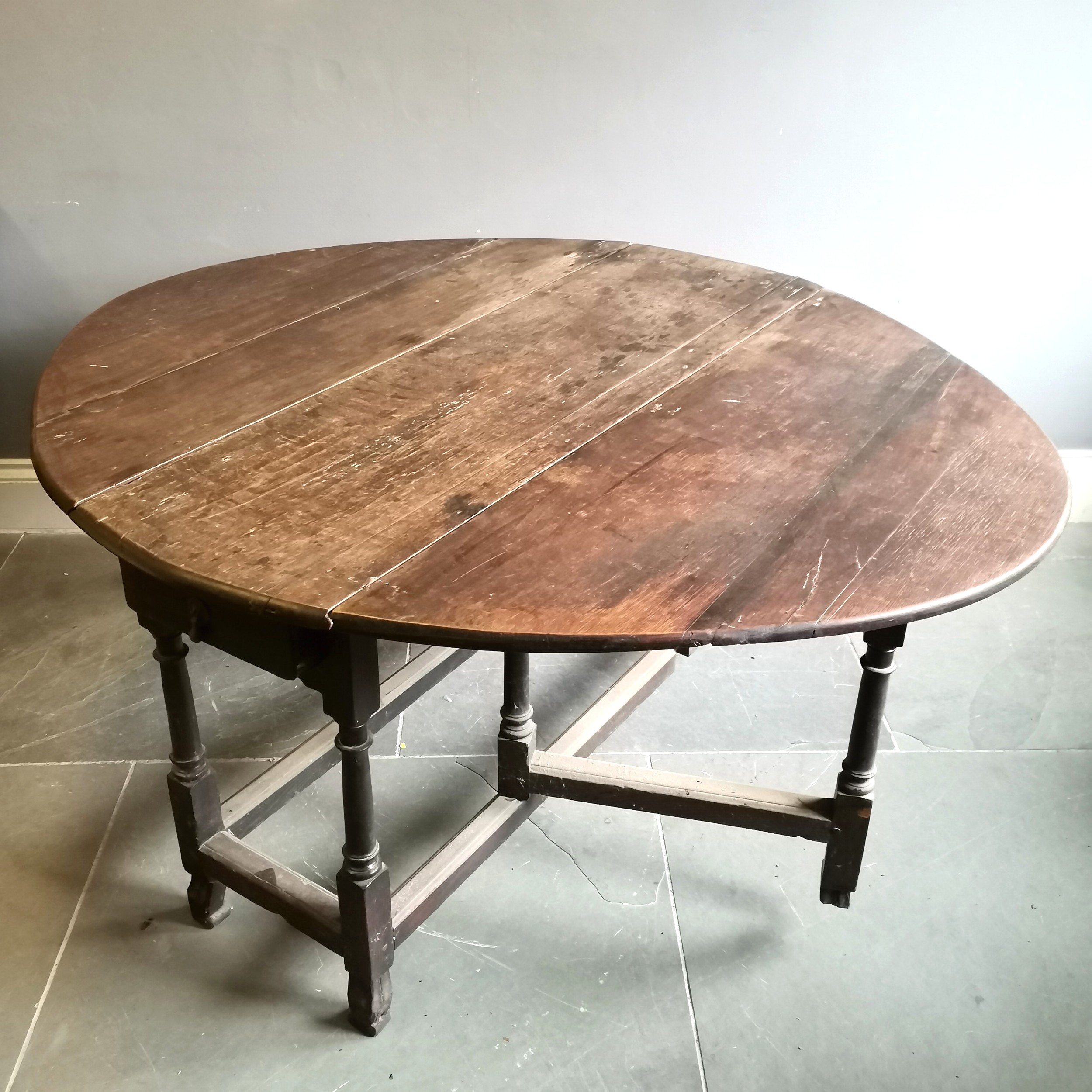 Antique oak gateleg dining table, on turned supports, resting on shaped feet, 137cm wide x 156cm