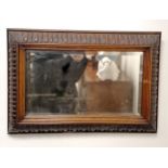 Antique oak framed cushion shaped, bevelled edge mirror, within carved frame, 53 cm high, 77 cm