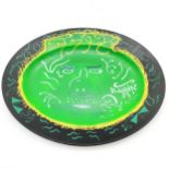1975 large oval studio pottery charger, black grounded with green head decoration signed JP - 41.5cm