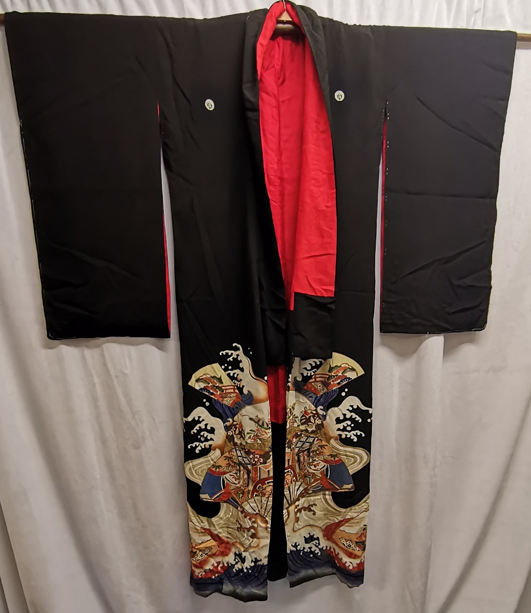 Black japanese kimono lined in red silk patterned to front in good condition.