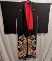 Black japanese kimono lined in red silk patterned to front in good condition.