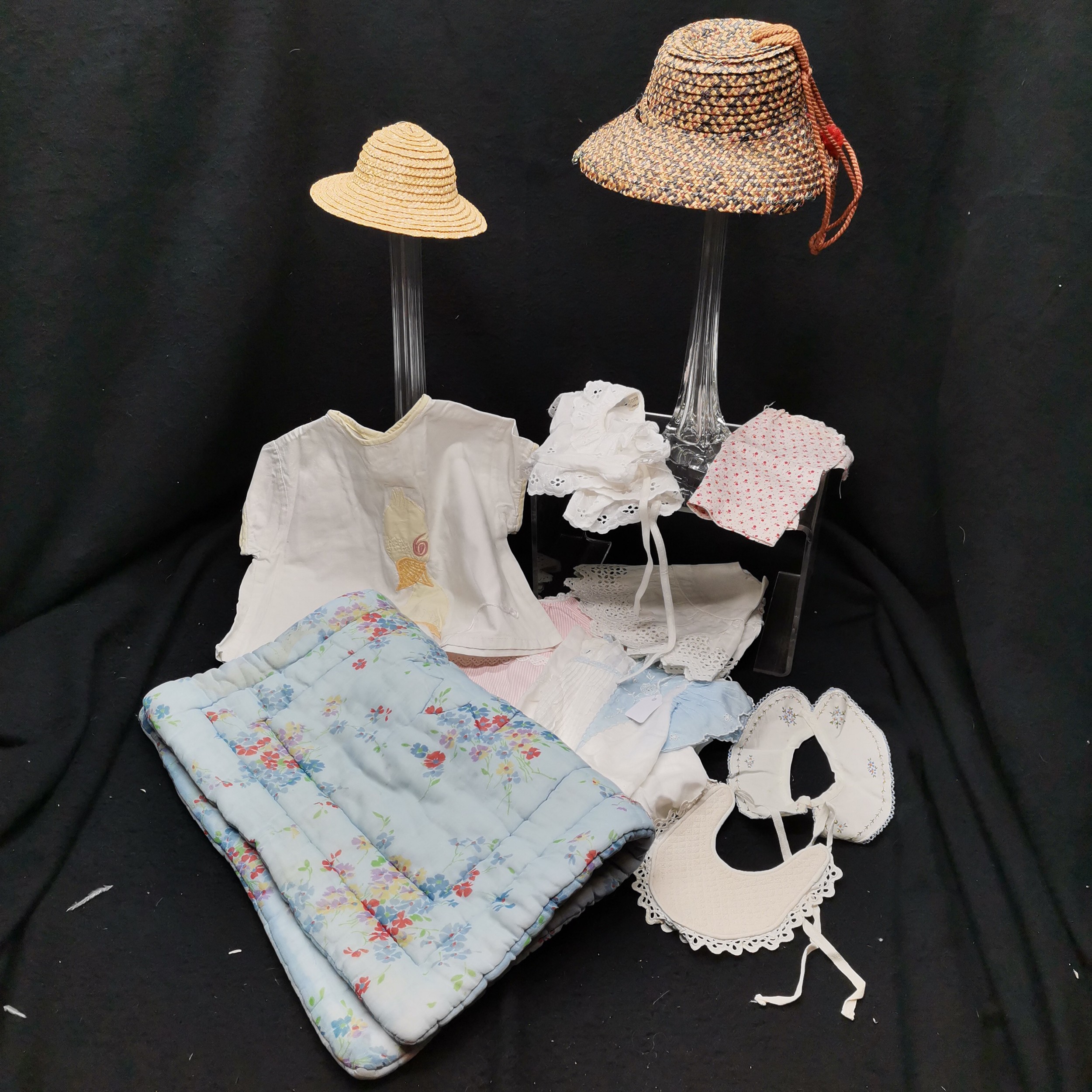 Dolls clothing to include bibs, hats, bedcovers, etc. Hat in need of repair, All in used condition.