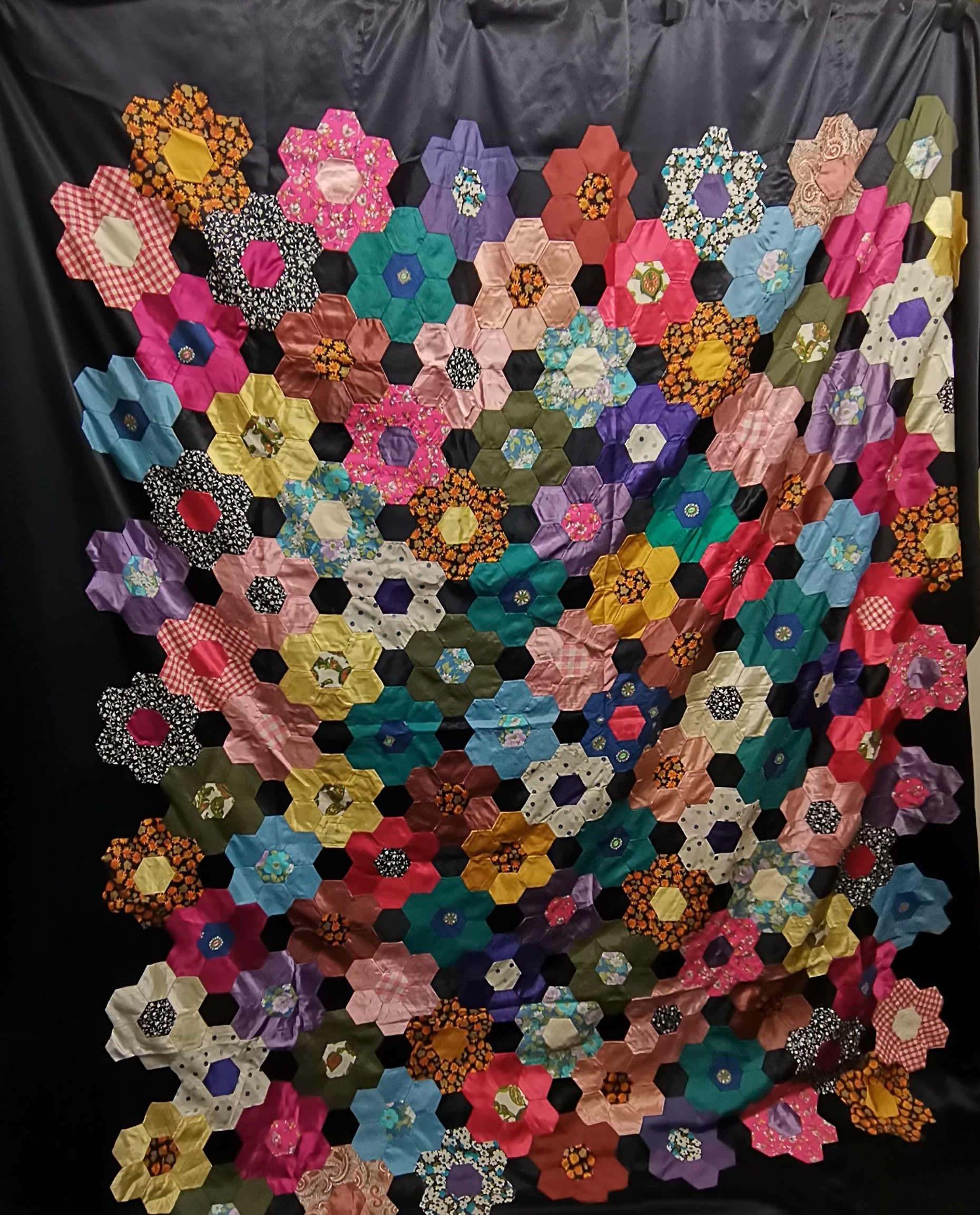 Quilt top mid century, a mix of silk, satin and cotton hexagonals on black background in very good