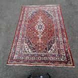 Large red grounded wool rug with blue detail to the border 310cm x 212cm