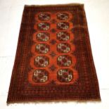 Brown ground rug with medallions within wide border, in good condition, 125 cm wide x 195 cm