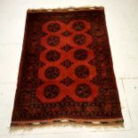 Red ground rug with all over medallions within border & pattern to fringing ~ 128cm x 188cm