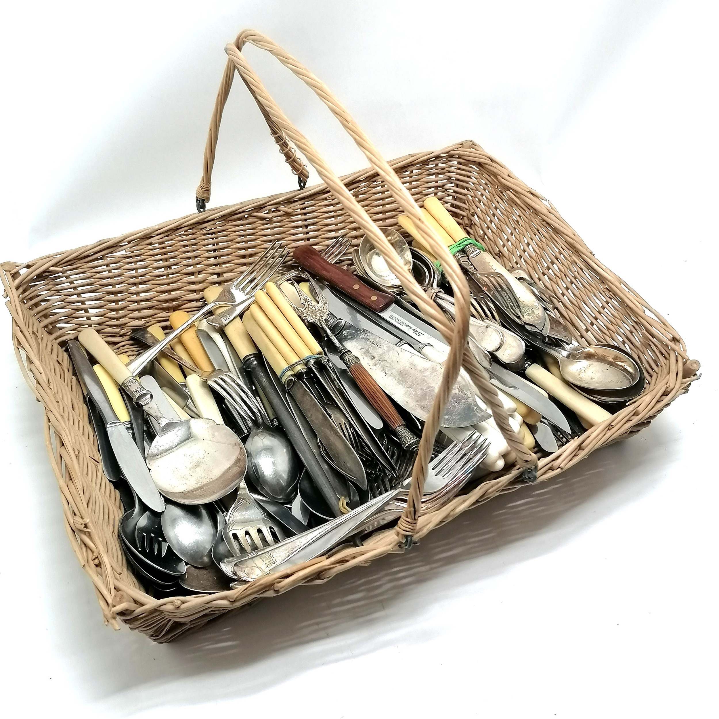 Quantity of loose flatware incl. a horn handled bread fork in a handled wicker basket