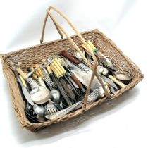 Quantity of loose flatware incl. a horn handled bread fork in a handled wicker basket