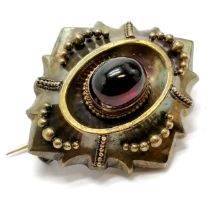 Antique unmarked gold (touch tests as 15ct) brooch set with a cabochon garnet - 4.2cm across & 10.9g
