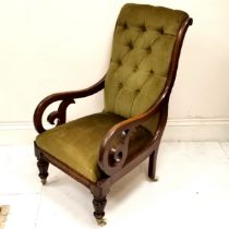 Antique mahogany framed button back library chair, upholstered in a green velvet, with c scroll arms