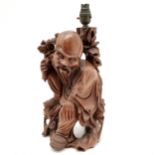 A Vintage oriental carved hardwood lamp in the form of a mandarin, holding flowers in 1 hand and