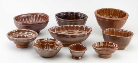 A collection of nine 19th century salt glazed jelly moulds, largest example with geometric