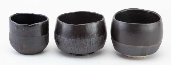 † ALEX HAGEN; a trio of stoneware bowls partially covered in black glaze, impressed marks, largest