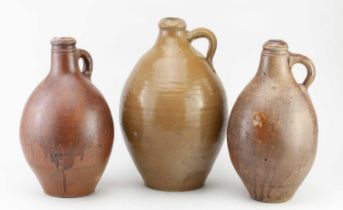 Two similar 18th century German bellarmine type jugs, tallest 30cm, and a similar larger jug