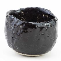 AKIKO HIRAI (born 1970); a stoneware chawan covered in pitted black glaze, impressed mark,