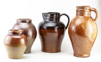 A large 19th century German salt glazed jug, height 38cm, a further salt glazed jug, and two storage
