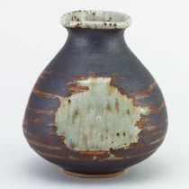 † BARBARA CASS (1921-1992); a faceted stoneware bottle covered in black slip and green ash glaze,