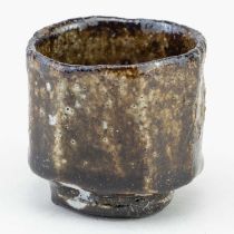 AKIKO HIRAI (born 1970); a small faceted stoneware guinomi covered in mottled iron glaze, incised