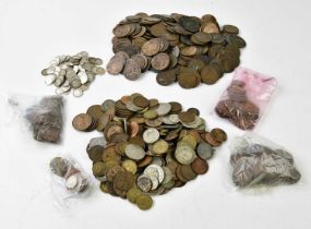 A collection of coins, predominantly British, including various pennies and threepence pieces.