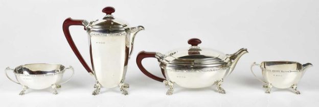 REID & SONS; a George VI hallmarked silver four piece tea service with panelled decoration and