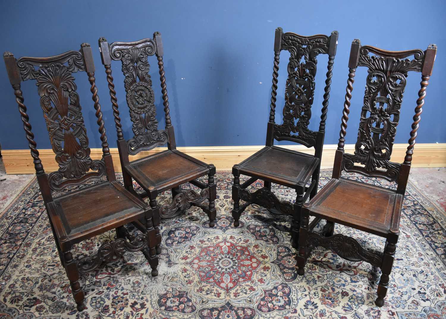 Four carved oak hall chairs with panelled seats (4).