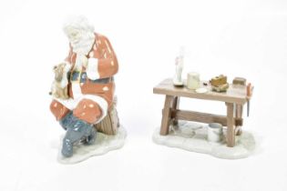 LLADRÓ; two boxed figures of Father Christmas and a model of a work bench with toys (2). Condition