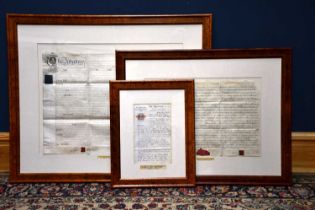 Two 18th century framed indentures, larger 86cm x 104cm, together with a smaller 19th century