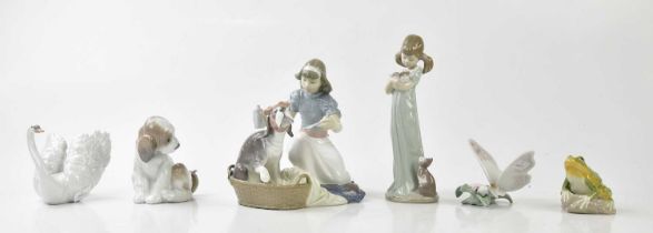 LLADRÓ; a model of a girl feeding a sick puppy, height 18cm, figure of a girl clutching a kitten,
