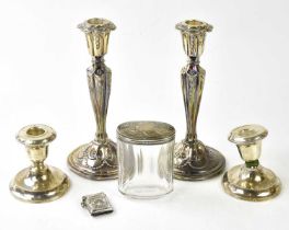 G.R & M; a pair of Victorian hallmarked silver candlesticks with embossed scrolling decoration,