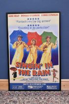 A reproduction "Singing in the Rain" film poster, 150 x 101cm, framed and glazed.