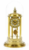 An early 20th century brass anniversary clock of cylindrical form, with applied finials above the