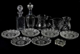 A collection of assorted cut and moulded glassware including decanters, various jugs, etc.