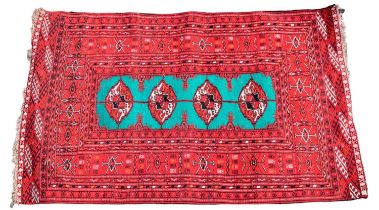 A small Bokhara type rug with devices set on a red ground, 125 x 84cm.